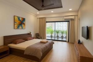 a bedroom with a large bed and a large window at Skywood Villa Rooms in Lucknow