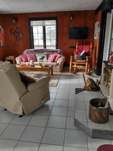 ein Wohnzimmer mit Sofas und Tischen in der Unterkunft Chalet Autrichien de la Cornière in Lac-Beauport