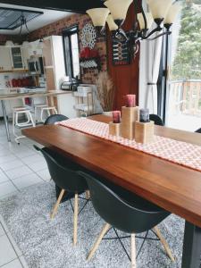 ein Tisch in einer Küche mit Stühlen drumherum in der Unterkunft Chalet Autrichien de la Cornière in Lac-Beauport