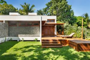 a modern house with a deck and grass at Casa Carcará a 300 m da praia de Taipu de Fora in Taipu