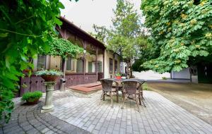 a patio with a table and chairs in front of a house at Tornácos Vendégház Kőröshegy in Kőröshegy