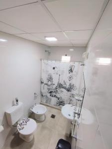 a white bathroom with two toilets and a sink at CTA DIVISION House in Malargüe +6 photos