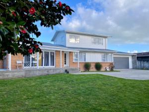 a large white house with a driveway at Quiet, private and 5-bedroom holiday house in Hamilton