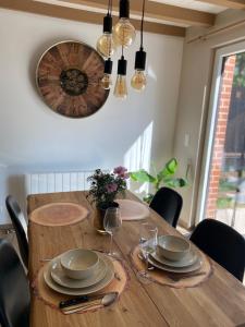 a dining room table with chairs and a clock on the wall at Romantik Wood in Waulsort +32 photos