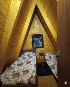an attic room with a bed and a window at Villa Roi in Ferizaj