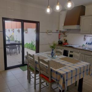 a kitchen with a table and some chairs and a table and a table at Comporta beach house in Carvalhal