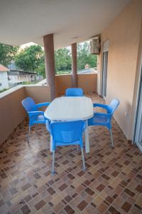 a white table and blue chairs on a balcony at Ajka apartments in Ulcinj +16 photos
