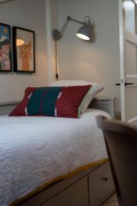 a bedroom with a bed with a pillow and a lamp at Bed, Boom en Droom in Rolde