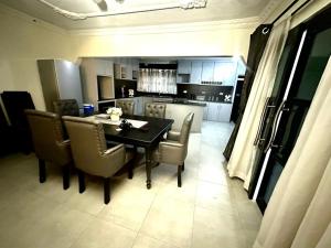 a kitchen and dining room with a table and chairs at Gogo Rennie Guest House in Umtali