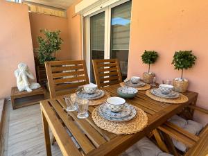 テウル・シュル・メールにあるFrench Riviera Escape - Théoule Hyper Centre - 2 Terrasses - Parkingの木製テーブル(皿、皿付)