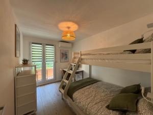 テウル・シュル・メールにあるFrench Riviera Escape - Théoule Hyper Centre - 2 Terrasses - Parkingのベッドルーム1室(二段ベッド2台、照明付)