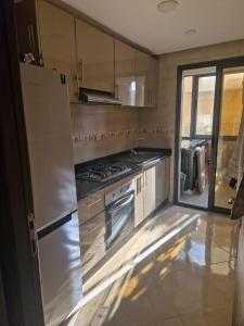 a kitchen with a stainless steel refrigerator and stove at الشروق 2 résidence chourouk 2 in Mansouria