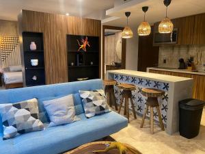a living room with a blue couch and a kitchen at Eco chic apartment in Tulum in Tulum