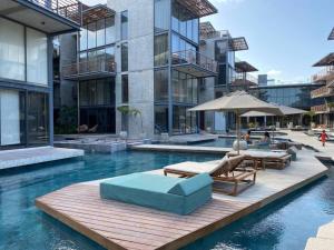 a swimming pool with chairs and an umbrella in a building at Eco chic apartment in Tulum in Tulum