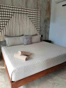 a bed with two towels on top of it at Eco chic apartment in Tulum in Tulum +2 photos