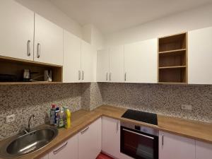 a kitchen with white cabinets and a sink at M&D Apartment in Struga