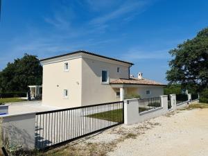 a white house with a fence in front of it at Villa V in Svetvinčenat