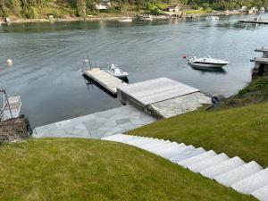 a dock with a boat in the water at Beachfront apartment with private swimming dock in Asker +7 photos