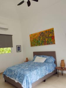 a bedroom with a bed and a painting on the wall at Villa en Guababerry in Los Conucos