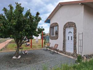 a small house with two chairs and a door at Taram de Poveste in Corbu