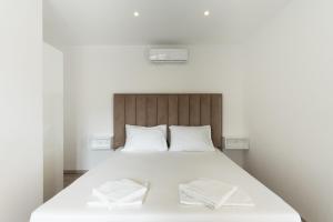 a bedroom with a white bed with two towels on it at Villa Marijo with a pool in Novalja +29 photos