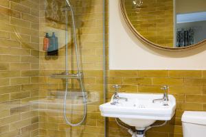 a bathroom with a shower and a sink and a mirror at Wychwood Cottage in Charlbury +12 photos