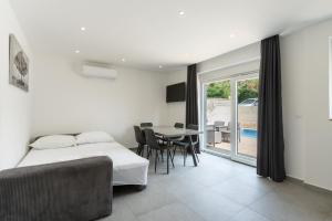 a bedroom with a bed and a table with chairs at Villa Marijo with a pool in Novalja