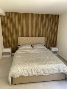 a bedroom with a large bed with two night stands at Two-room apartment in Villiers-le-Bel