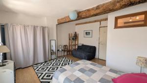 a bedroom with a bed and a couch in a room at Le Nid de Marguerite in Castelnaudary