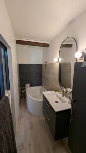 a bathroom with a tub and a sink and a mirror at Le Nid de Marguerite in Castelnaudary +44 photos