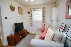 a living room with a couch and a tv at Home close to city center home in Milton Keynes