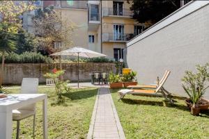 a garden with chairs and an umbrella and a building at Casa in centro con ampio giardino in Pescara