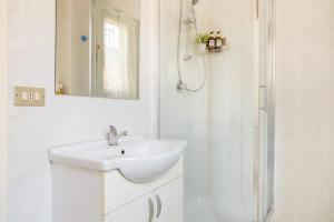 a white bathroom with a sink and a shower at Casa in centro con ampio giardino in Pescara +23 photos