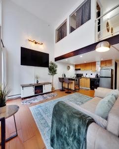 un grand salon avec un canapé et une télévision dans l'établissement Cozy Two-story Loft in Downtown, à Vancouver