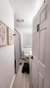 a white bathroom with a toilet and a door at Grand Manor - Big 2 Bedroom - USA Side in Niagara Falls