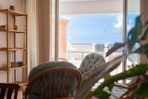 ein Zimmer mit Stühlen und einem großen Fenster in der Unterkunft Casa da Maresia - The Seaside Escape in Paul do Mar