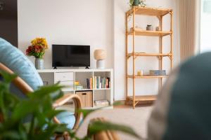 ein Wohnzimmer mit Fernseher und Bücherregal in der Unterkunft Casa da Maresia - The Seaside Escape in Paul do Mar + 19 Fotos
