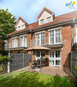 a brick house with a table and chairs in the yard at Villa Cila Ferienwohnung 3 in Wangerooge