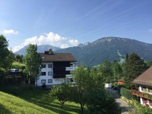 a white building with mountains in the background at Allgäu Appartementhaus Appartement ALLGÄU 02 in Pfronten