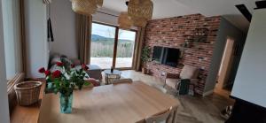 a living room with a table and a brick wall at Wzgórze Wadery Siekierczyna in Siekierczyna +17 photos