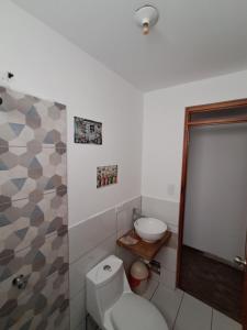 a bathroom with a white toilet and a shower at Bellavista Hospedaje Vista asombrosa in Oxapampa