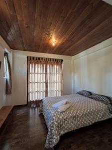 a bedroom with a bed with a wooden ceiling at Bellavista Hospedaje Vista asombrosa in Oxapampa