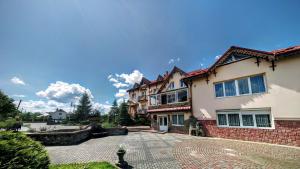 a house with a cobblestone driveway in front of it at Hotel Complex Knyaz Oleg in Dolyna