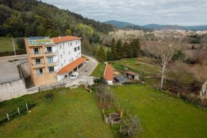 an aerial view of a building in a green field at Apartamento Equitare Rural na Serra de Lousã in Miranda do Corvo