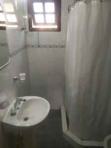 a bathroom with a sink and a shower curtain at Doña Mecha in Santa Rosa de Calamuchita