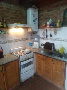 a small kitchen with a stove and a sink at Doña Mecha in Santa Rosa de Calamuchita