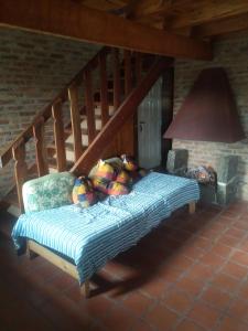 a bed in a room with a wooden staircase at Doña Mecha in Santa Rosa de Calamuchita