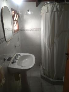 a bathroom with a sink and a shower curtain at Doña Mecha in Santa Rosa de Calamuchita