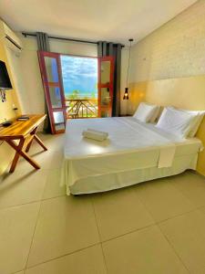 a bedroom with a large bed and a balcony at Hotel das Marés in Trairi +59 photos