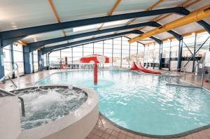 a large swimming pool with a hot tub in a building at 6 Birth Caravan Quay West Sea Views in New Quay